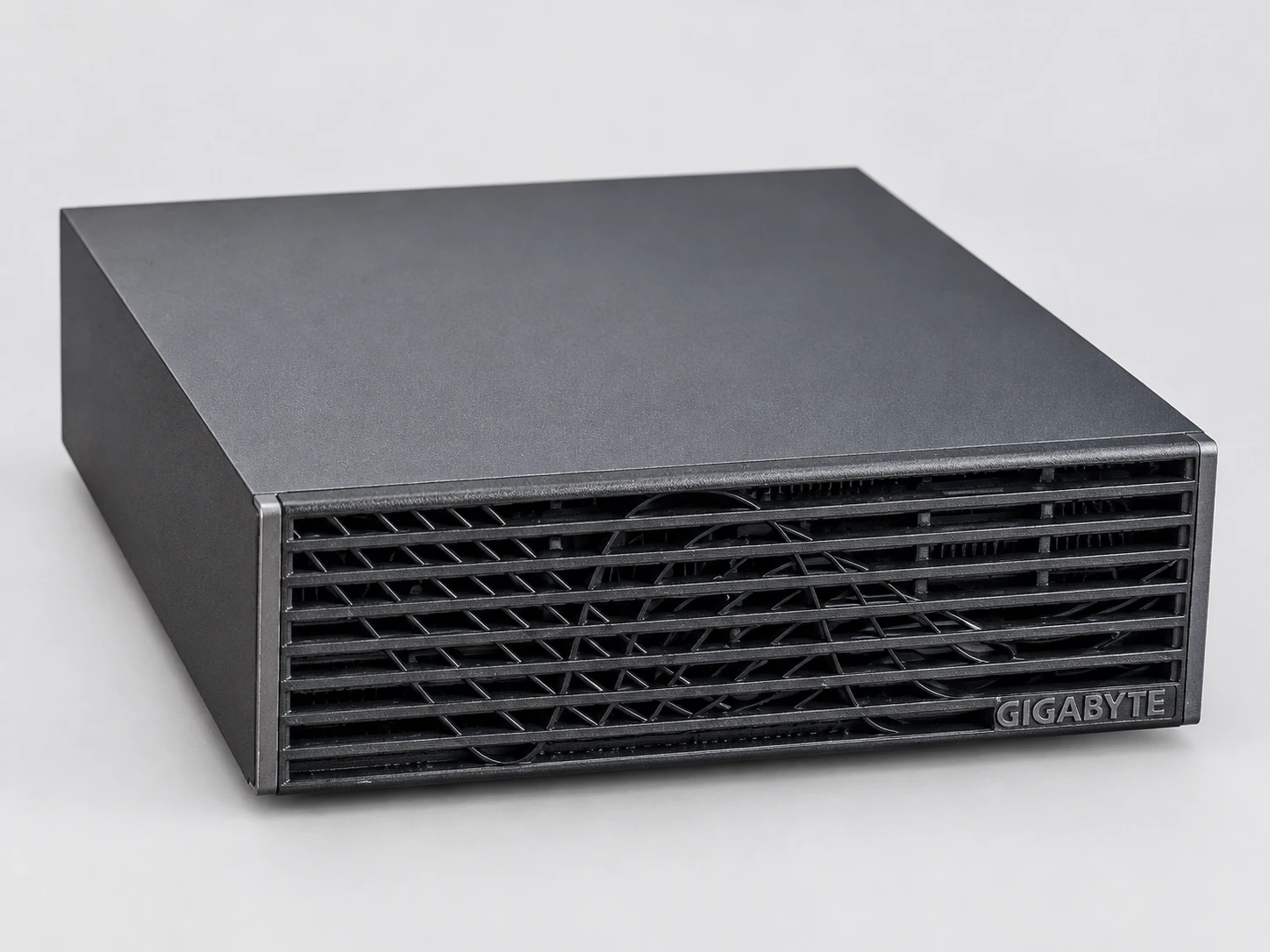 右側から見た GIGABYTE AI TOP ATOM の斜め前方からの外観。平らに置かれ、チャコールグレーの天板と黒いスリット状の前面。